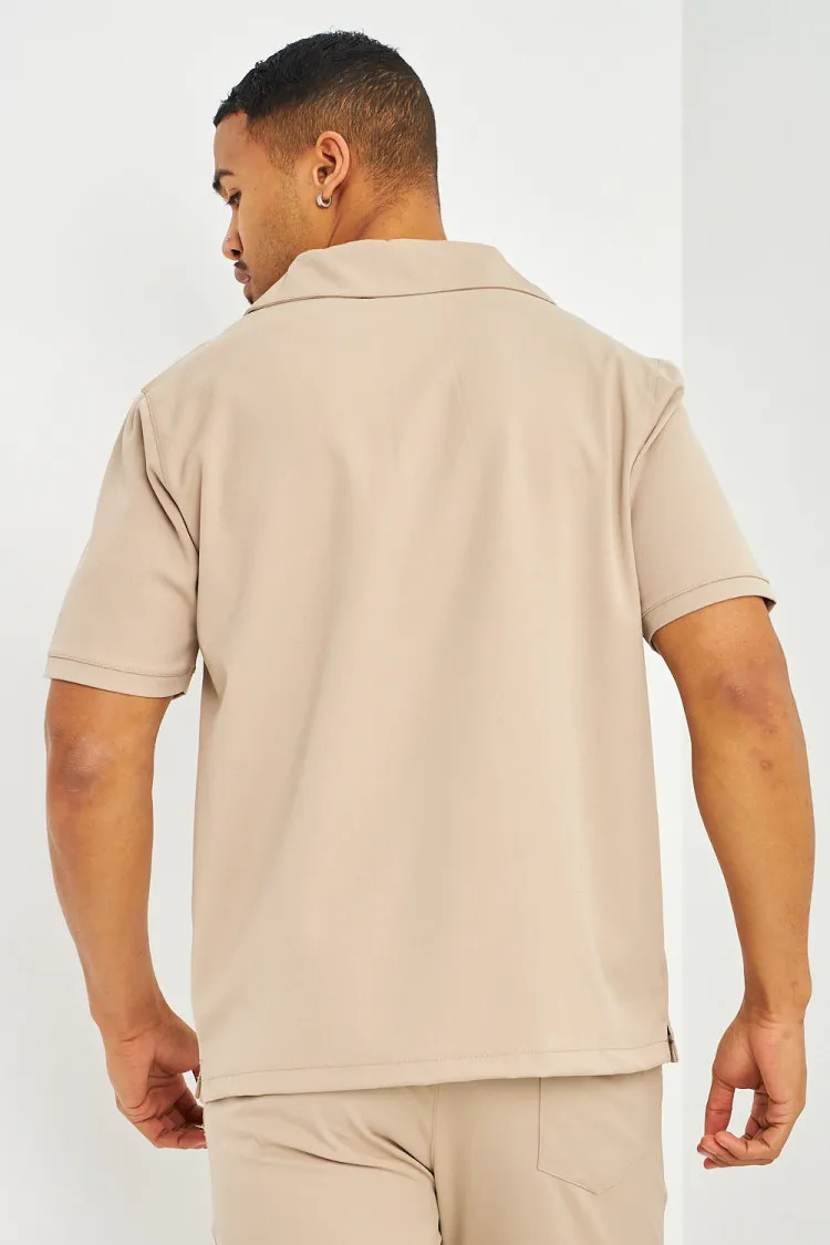 Polo uni beige col zippé à poches